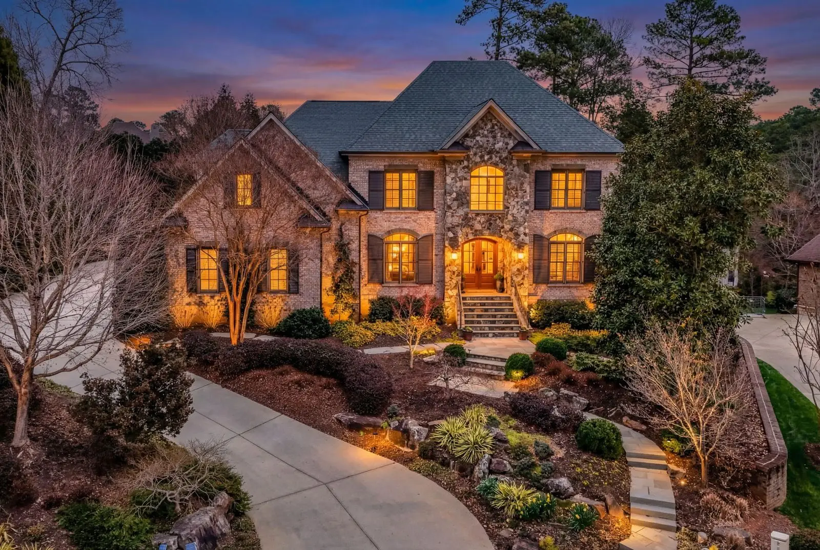 Aerial of 3604 Nightfall Ct showing the saltwater pool, outdoor kitchen, and wooded Umstead Park backdrop