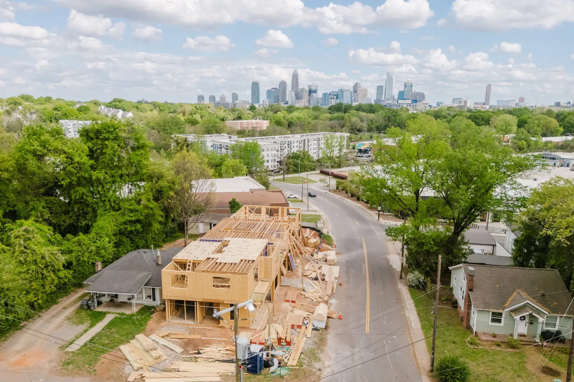Aerial drone shot of a Charlotte construction site mid-vertical-build at golden hour