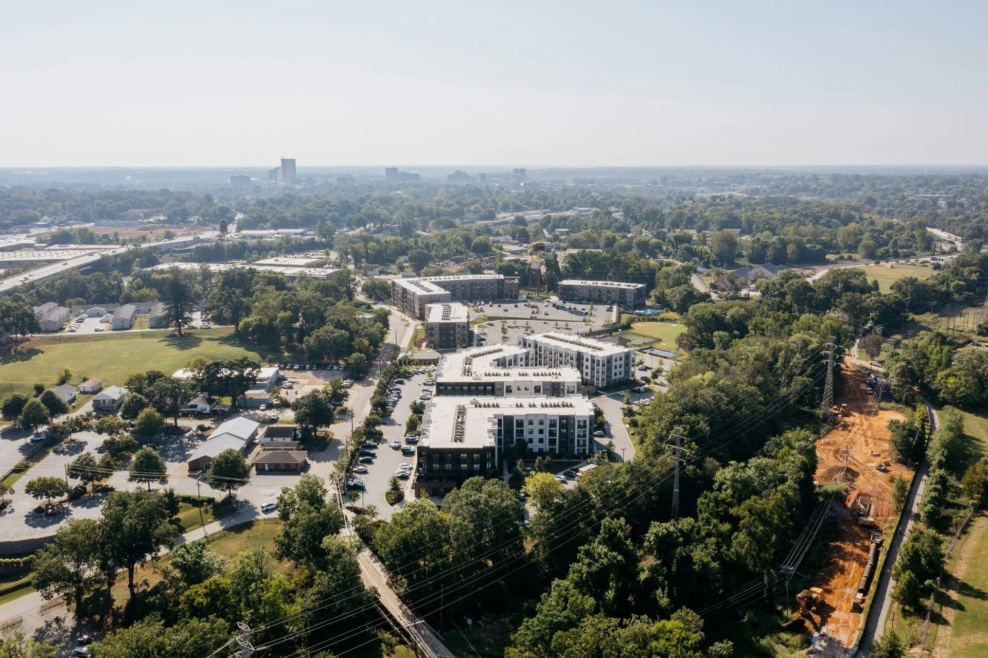 Aerial view of a multifamily community showing the building layout, parking, and amenity areas in context